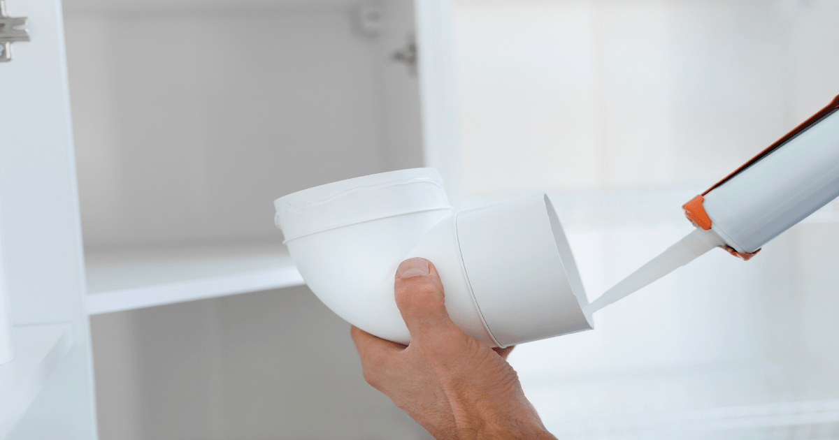 Een specialist installeert een ventilatiesysteem.