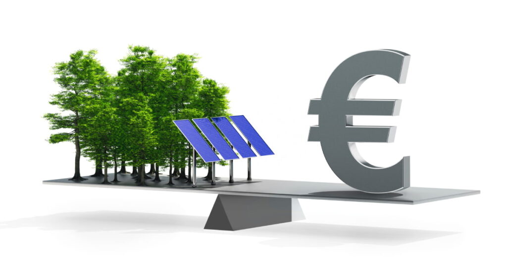 Deze foto toont een weegschaal met aan de ene kant groene energie en aan de andere kant een euroteken.