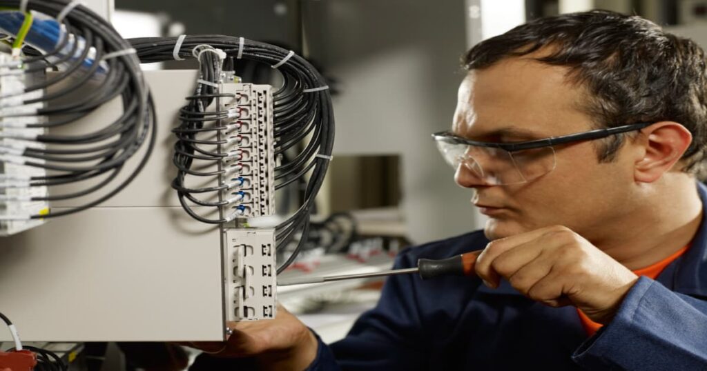 Een elektricien die gefocust zijn job doet.