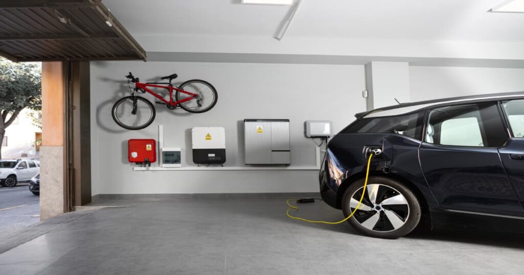 Een auto die aan het opladen is via een stekker die stroom genereert via een thuisbatterij.
