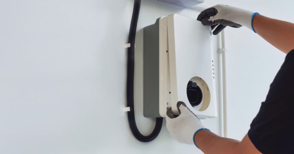 Een vakspecialist zet het deksel van de thuisbatterij op de doos.