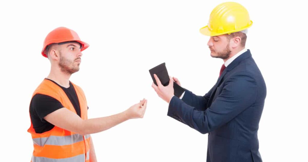 Een man in maatpak die zijn portefeuille boven haalt om een vakman te betalen.