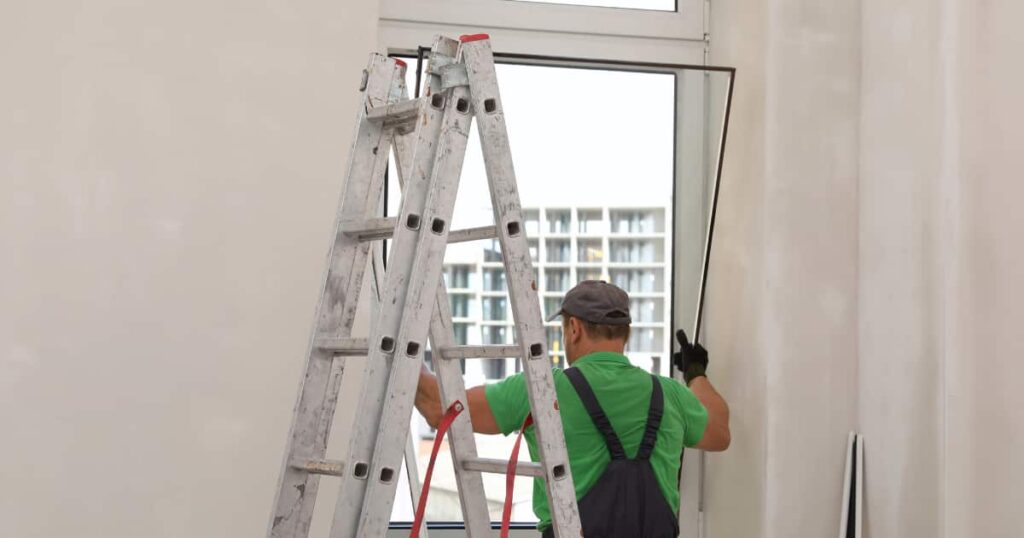 Een specialist die volledig nieuwe beglazing in een raam plaatst.