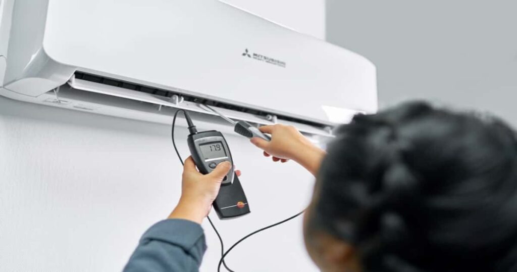Een vakman dat de temperatuurt regelt van een Mitsubishi airco.